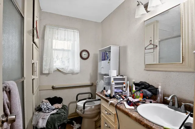 a bathroom with a sink mirror and a toilet