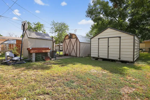 a view of a house with a yard and a wooden fence