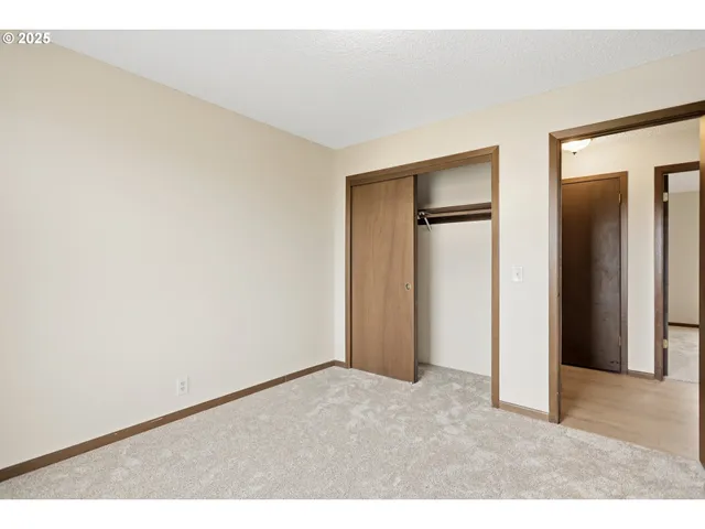 an empty room with closet and wooden floor
