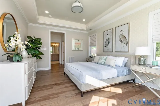 a spacious bedroom with a large bed chandelier and a window