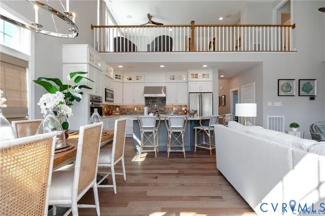 a living room with furniture a potted plant and open kitchen view
