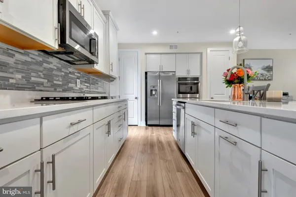 a kitchen with white cabinets and stainless steel appliances