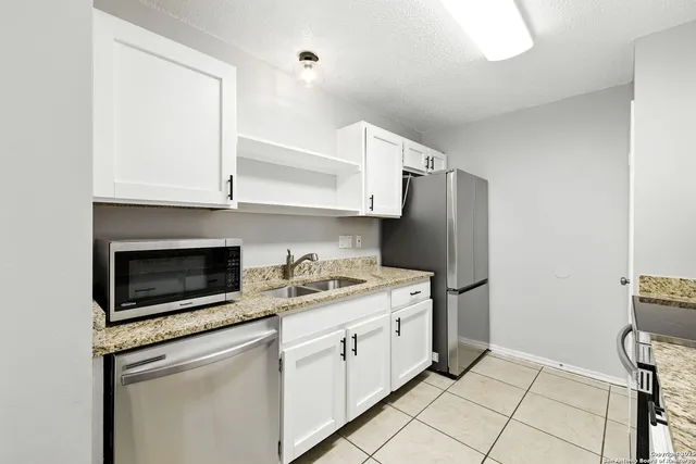 a kitchen with stainless steel appliances a stove microwave and refrigerator