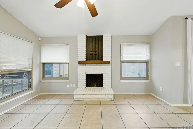 a view of an empty room with window and fire place