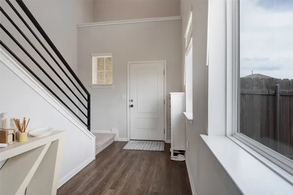 a view of a hallway with wooden floor and staircase