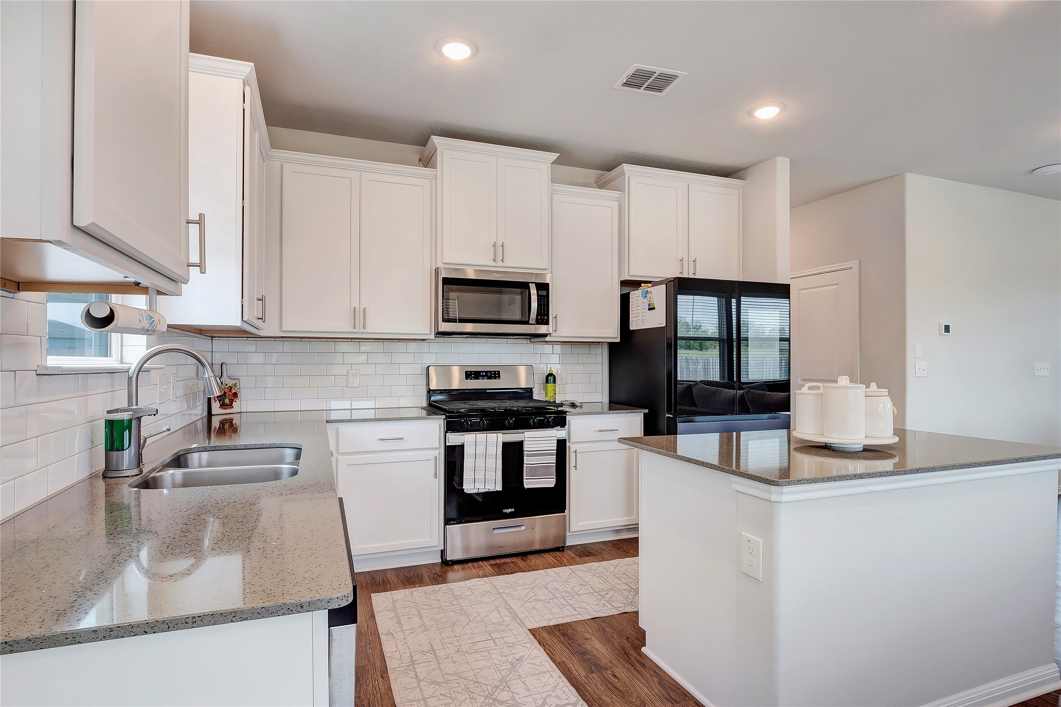 6554 Marsh Lane Buda, TX 78610 - Photo 6 of 30 a kitchen with stainless steel appliances granite countertop a sink stove and refrigerator