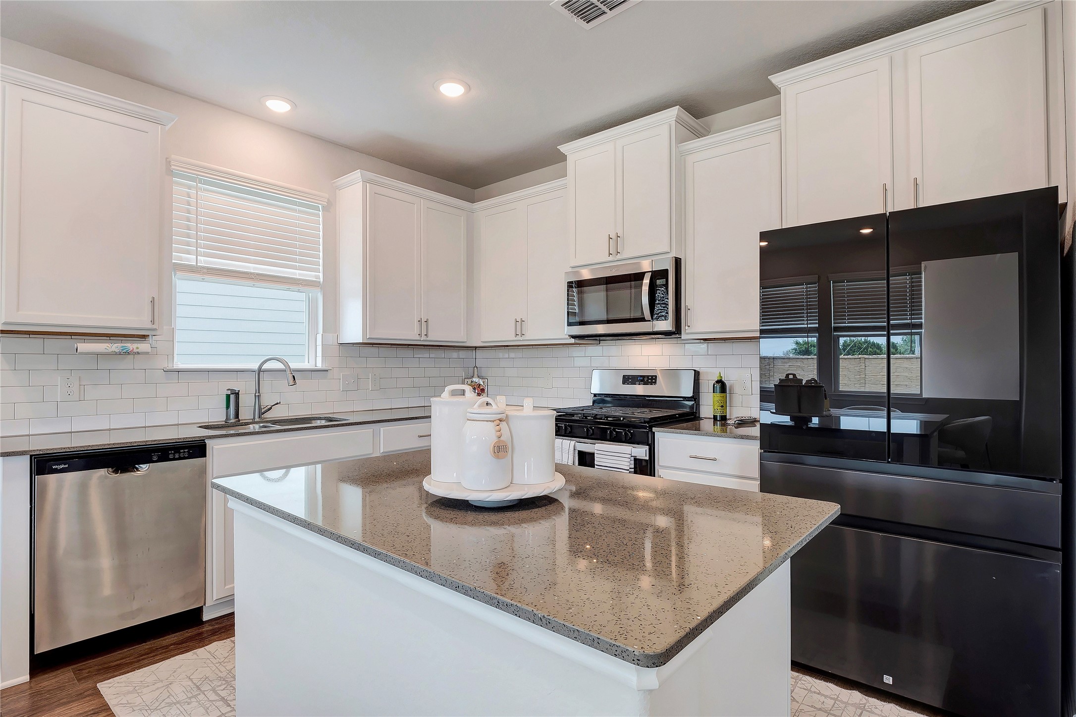 6554 Marsh Lane Buda, TX 78610 - Photo 7 of 30 a kitchen with a sink a stove and cabinets