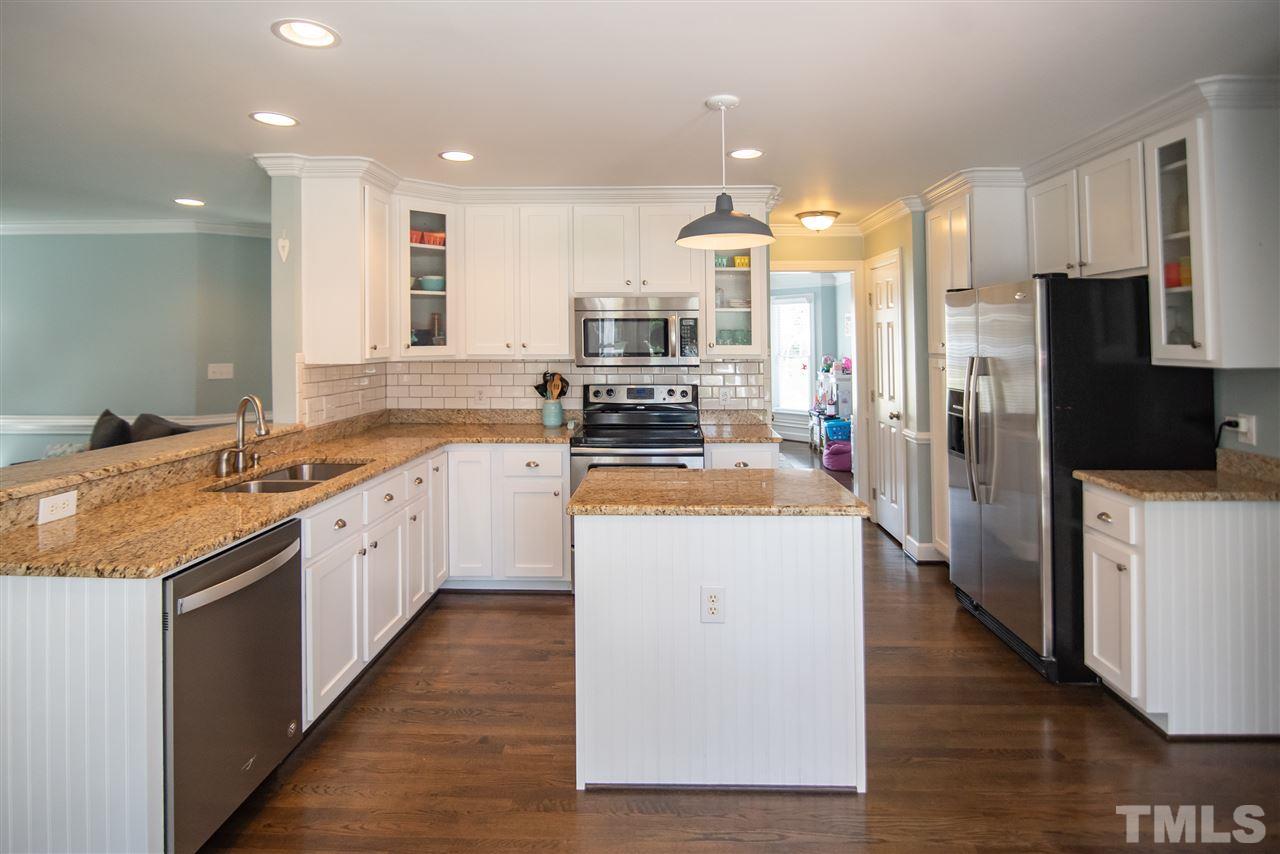 9116 Dawnshire Road Raleigh, NC 27615 - Photo 10 of 30 a large kitchen with stainless steel appliances kitchen island granite countertop a large counter top and stainless steel appliances
