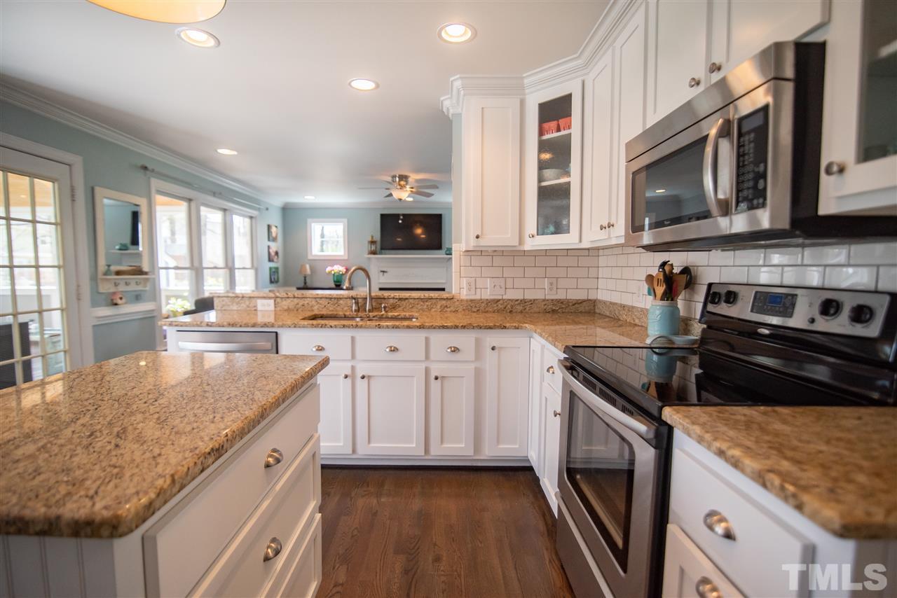 9116 Dawnshire Road Raleigh, NC 27615 - Photo 11 of 30 a kitchen with stainless steel appliances granite countertop a sink stove microwave and cabinets