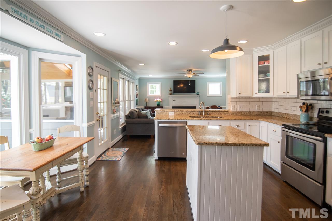 9116 Dawnshire Road Raleigh, NC 27615 - Photo 13 of 30 a kitchen with stainless steel appliances granite countertop a stove top oven a sink dishwasher a dining table and chairs with wooden floor
