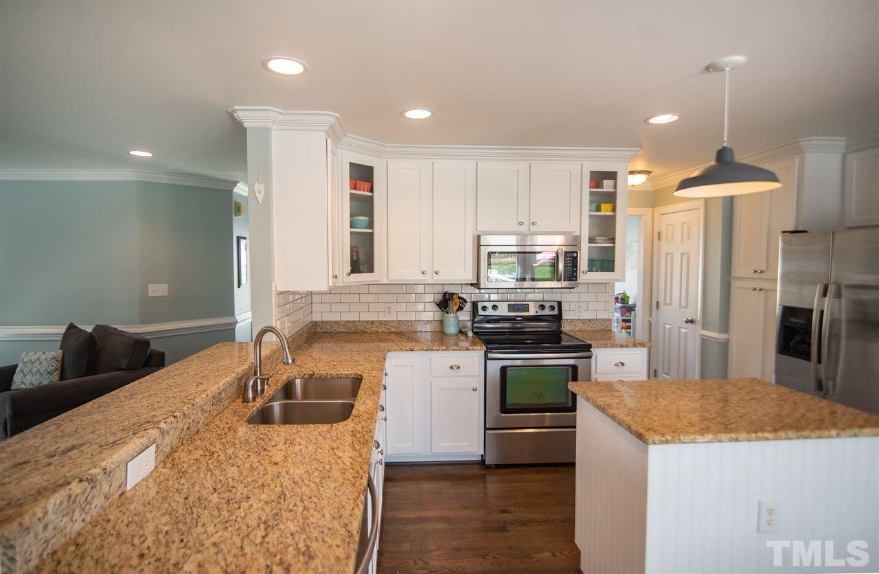 9116 Dawnshire Road Raleigh, NC 27615 - Photo 14 of 30 a kitchen with a stove a refrigerator and a sink