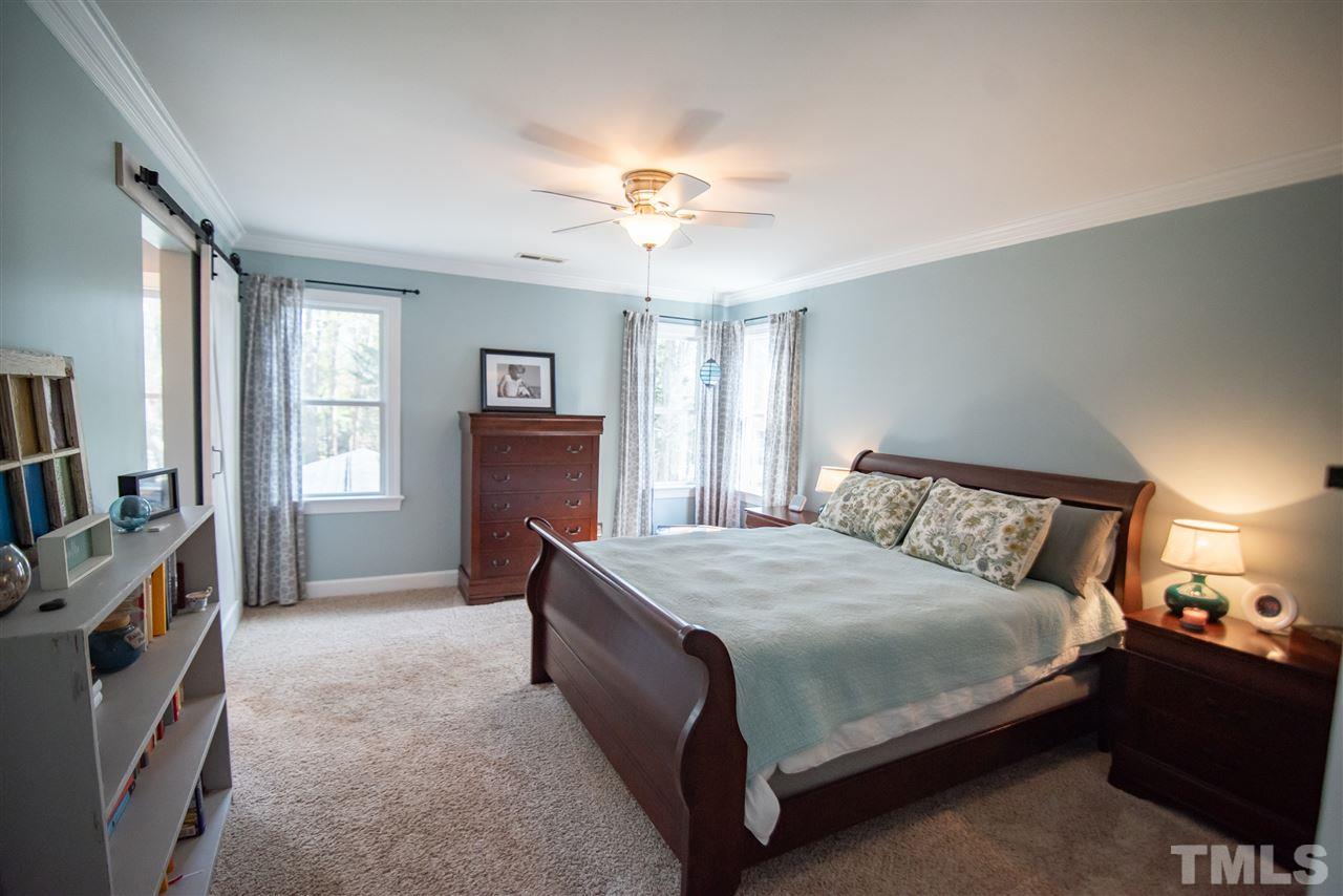9116 Dawnshire Road Raleigh, NC 27615 - Photo 16 of 30 a bedroom with a bed and a flat tv screen on dresser