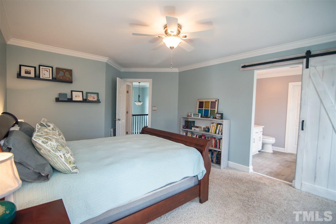 9116 Dawnshire Road Raleigh, NC 27615 - Photo 17 of 30 a bedroom with a bed and a chandelier