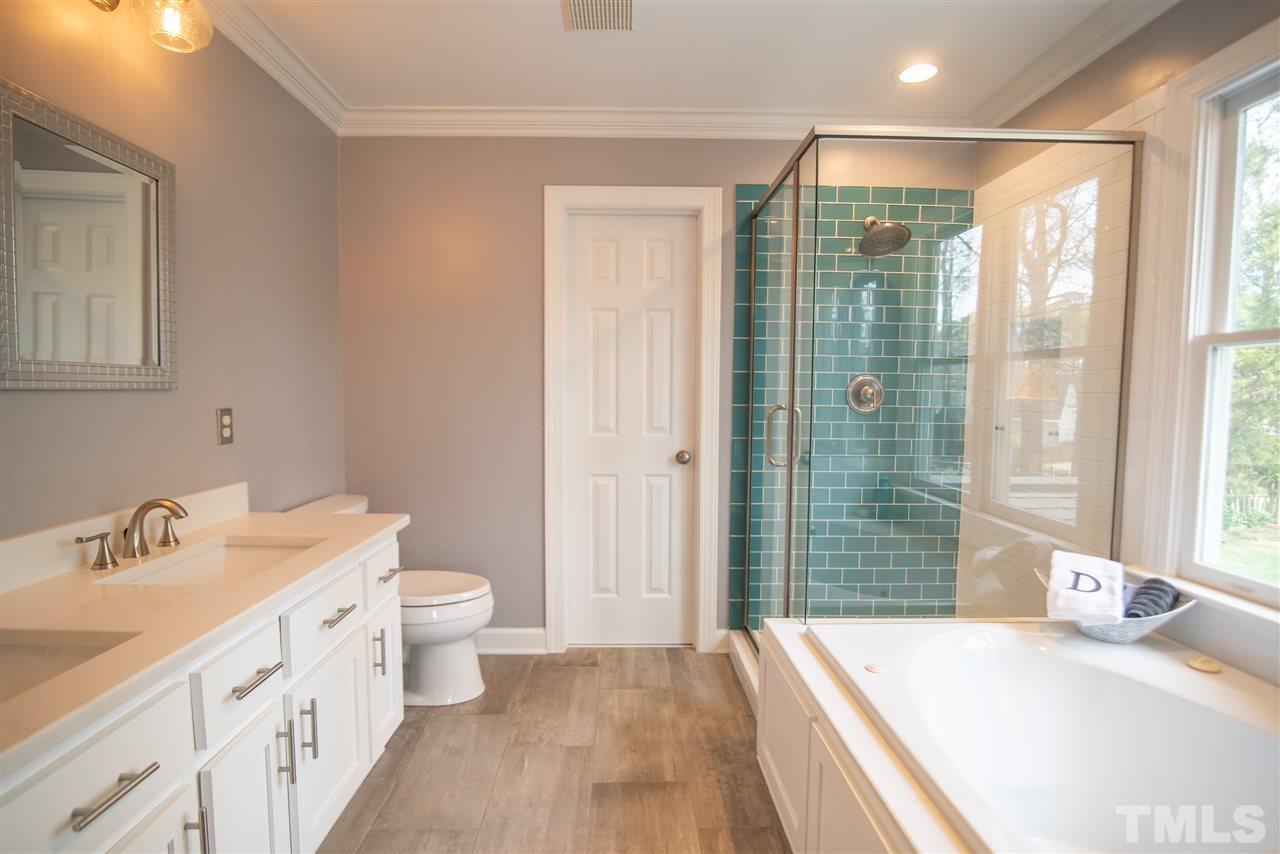 9116 Dawnshire Road Raleigh, NC 27615 - Photo 18 of 30 a bathroom with a double vanity sink toilet and shower