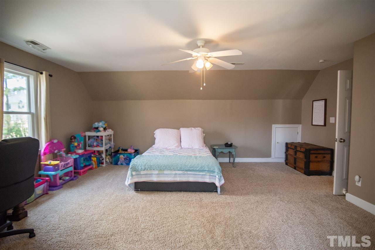9116 Dawnshire Road Raleigh, NC 27615 - Photo 22 of 30 a bedroom with bed and a chandelier