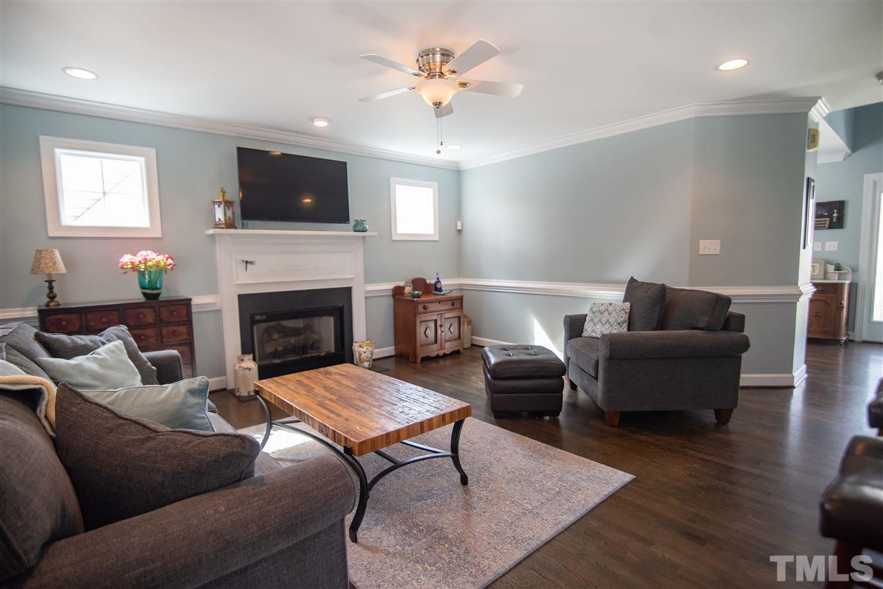 9116 Dawnshire Road Raleigh, NC 27615 - Photo 8 of 30 a living room with furniture a fireplace and a flat screen tv