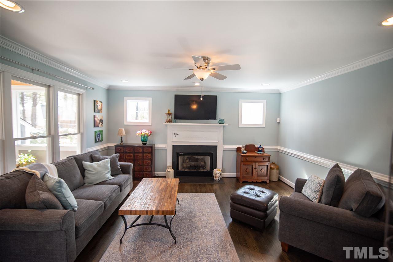 9116 Dawnshire Road Raleigh, NC 27615 - Photo 9 of 30 a living room with furniture a fireplace and a flat screen tv