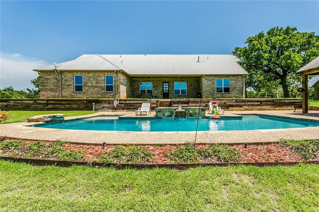 a aerial view of a house with swimming pool and a yard