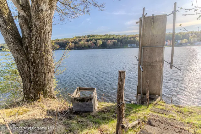 a white house with a big yard and large trees