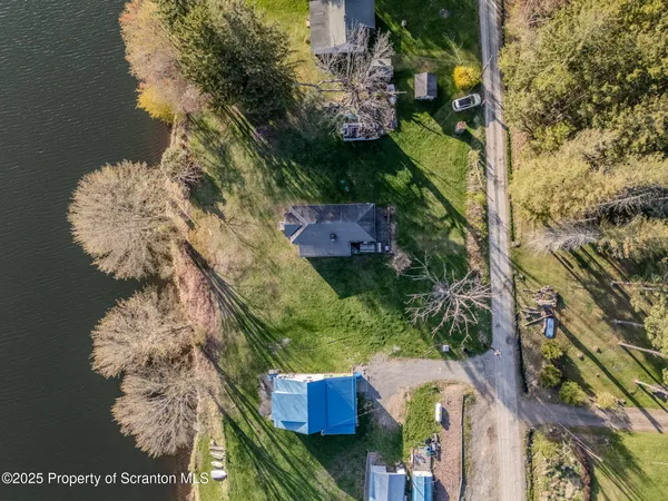a aerial view of a house with a yard and lake view