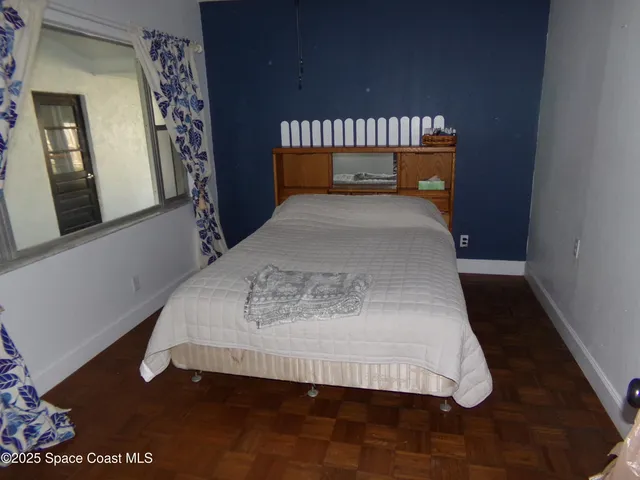 a bed sitting in a bedroom next to a window