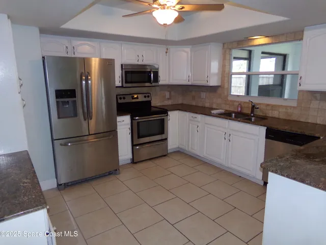 a kitchen with stainless steel appliances granite countertop a sink a stove a microwave a counter top space and cabinets