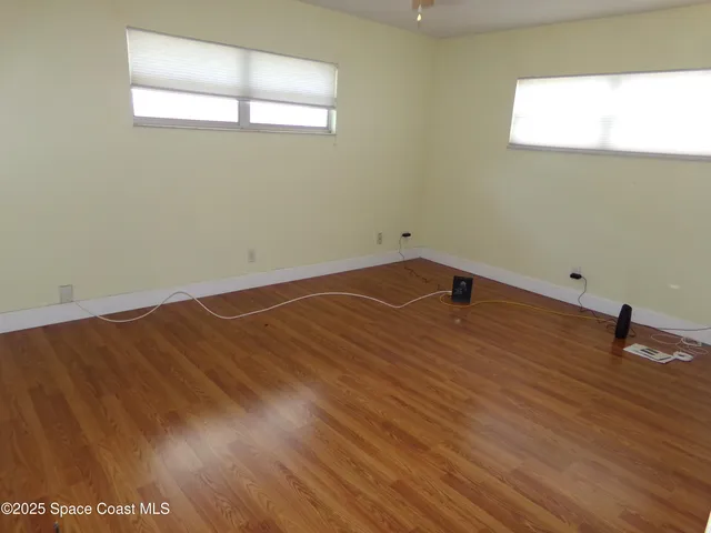 a view of a room with wooden floor and white walls