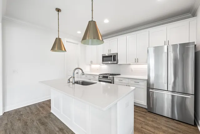 a kitchen with kitchen island white cabinets and white appliances