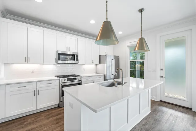 a kitchen with stainless steel appliances a stove a microwave and a window