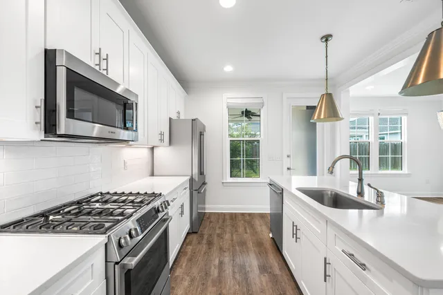 a kitchen with stainless steel appliances kitchen island a stove a sink and a microwave