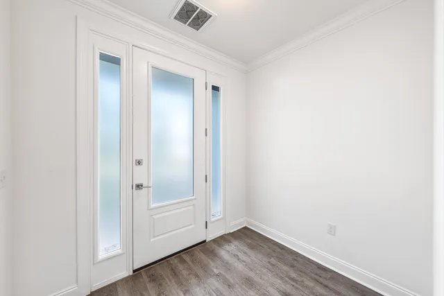 a view of an empty room with wooden floor and closet