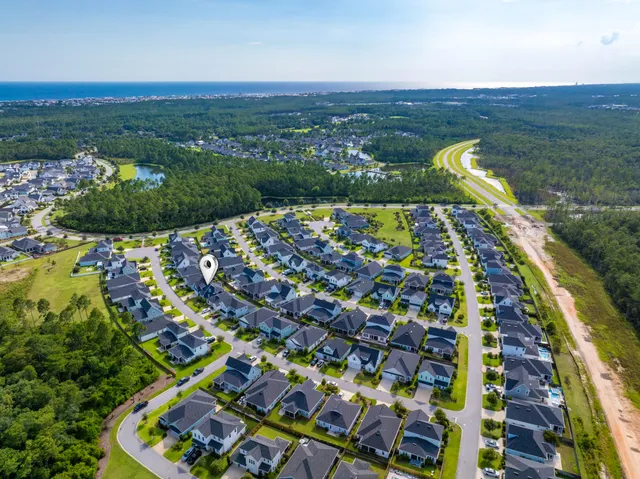 an aerial view of residential houses with outdoor space and swimming pool