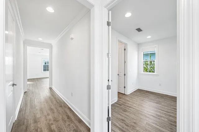 a view of a hallway with wooden floor and closet