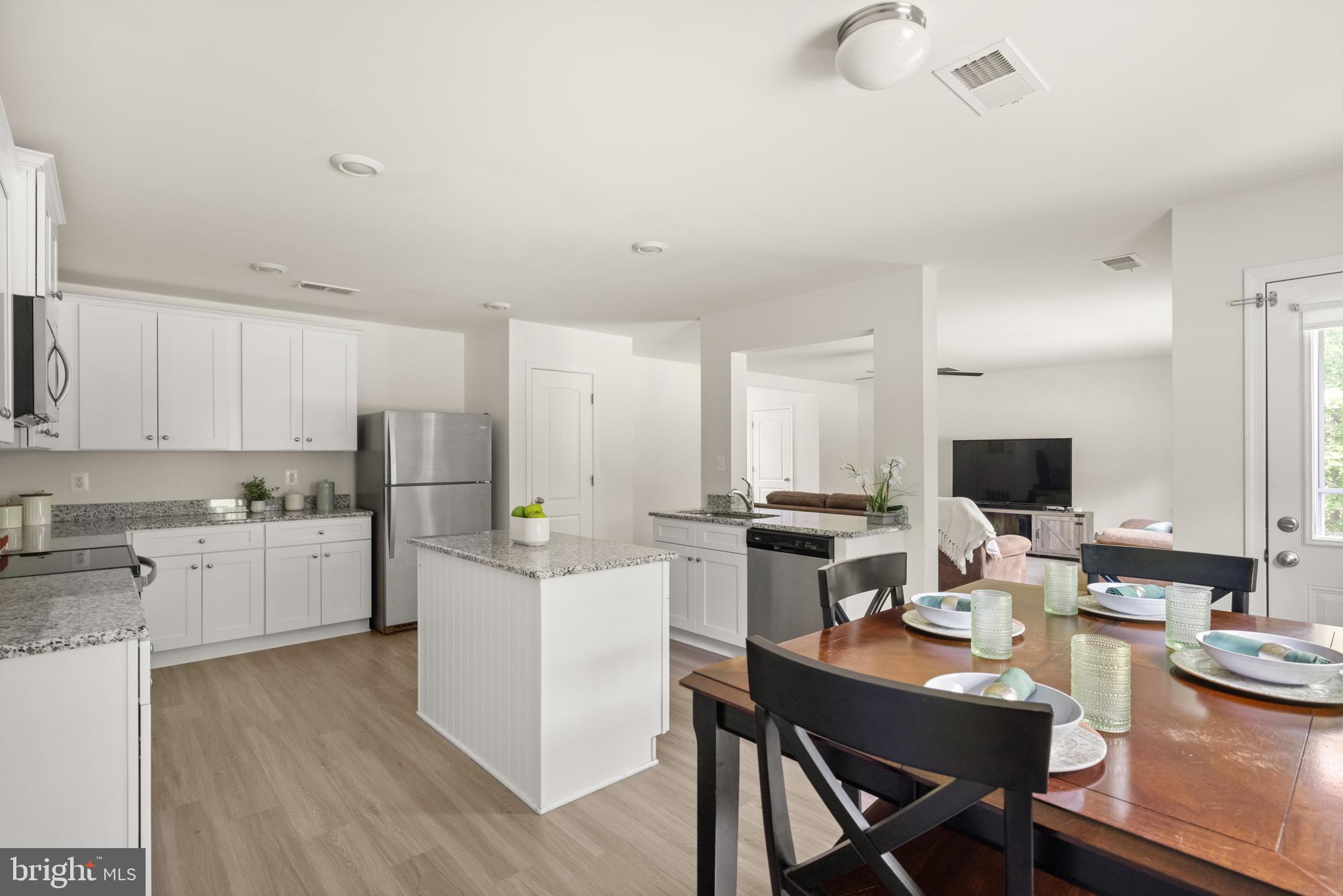 259 Headwaters Drive Falling Waters, WV 25419 - Photo 10 of 34 a kitchen with a dining table chairs stove and white cabinets