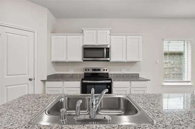 a view of an empty room with wooden floor and windows