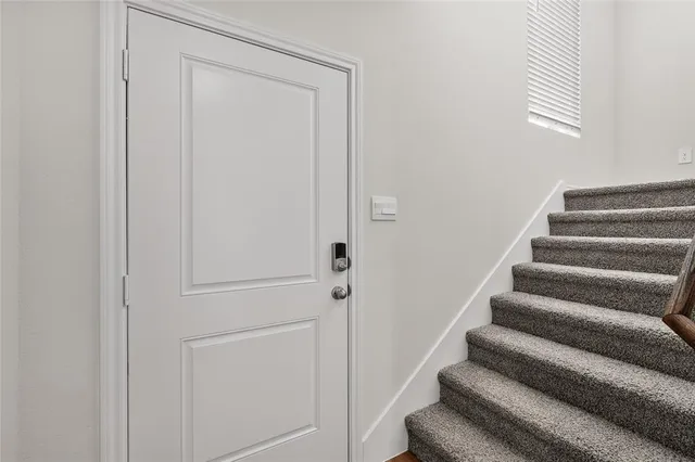 a kitchen with stainless steel appliances granite countertop a stove a sink a refrigerator white cabinets and wooden floor