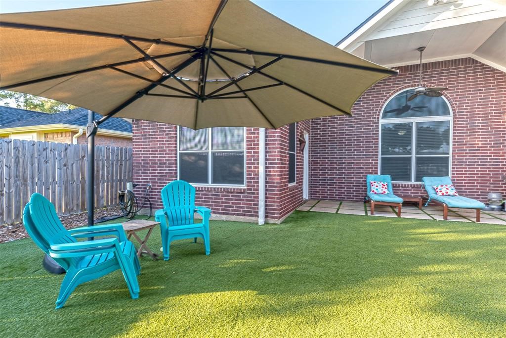 20235 Concord Hill Drive Cypress, TX 77433 - Photo 27 of 27 a patio with a table and chairs under an umbrella