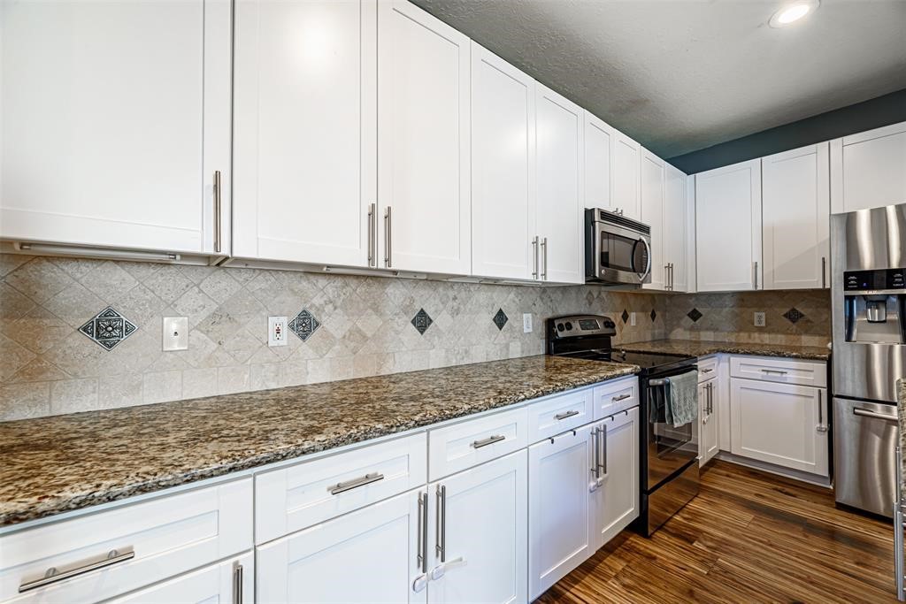 20235 Concord Hill Drive Cypress, TX 77433 - Photo 8 of 27 a kitchen with granite countertop white cabinets and white appliances
