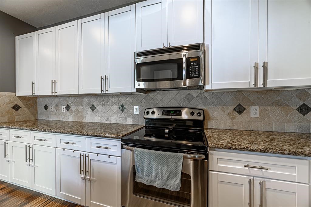 20235 Concord Hill Drive Cypress, TX 77433 - Photo 9 of 27 a kitchen with granite countertop white cabinets and stainless steel appliances