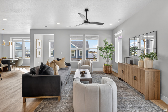 2841 West 2705 North, Unit 69 Ogden, UT 84404 - Photo 11 of 31 Spacious living area featuring light wood-finish flooring in the dining space, a modern ceiling fan, recessed lighting, and multiple windows providing natural light