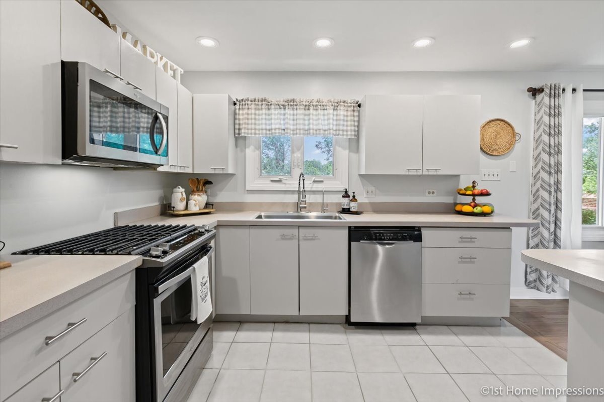 15309 Walnut Road Oak Forest, IL 60452 - Photo 10 of 26 a kitchen with stainless steel appliances granite countertop a stove a sink and a microwave