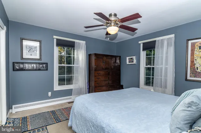 a bedroom with furniture and a large window