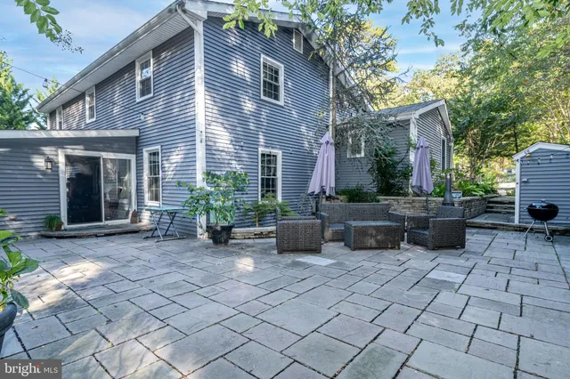 a view of a house with a backyard and chairs