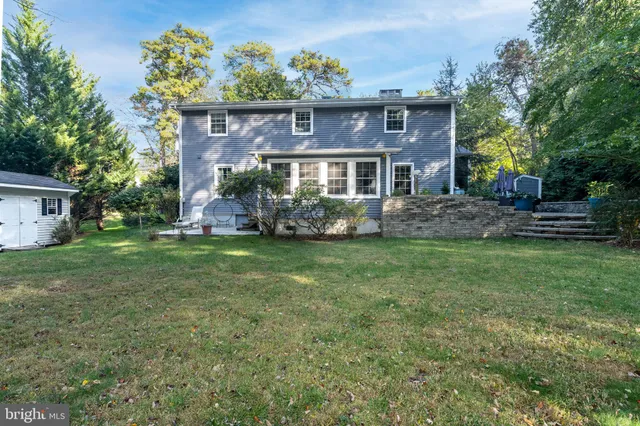 an aerial view of a house with a yard and large trees