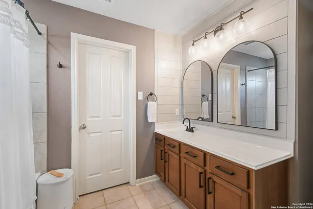 a bathroom with a double vanity sink and a mirror