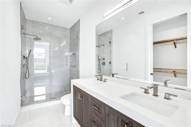 a bathroom with a double vanity sink mirror double shower and a bathtub