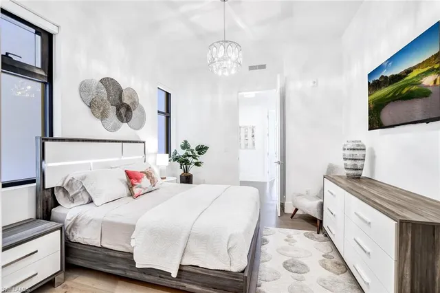 a bedroom with a bed and a flat tv screen on dresser