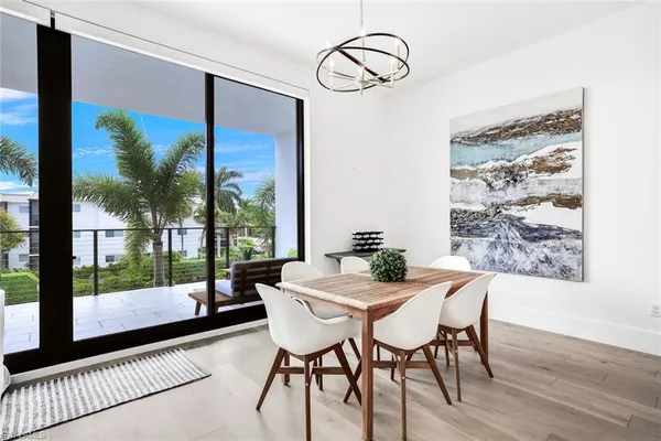 a view of a dining room with furniture wooden floor and a floor to ceiling window