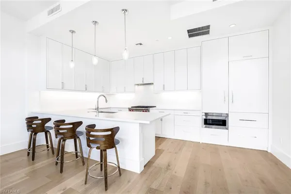 a kitchen with a table chairs stove and white cabinets