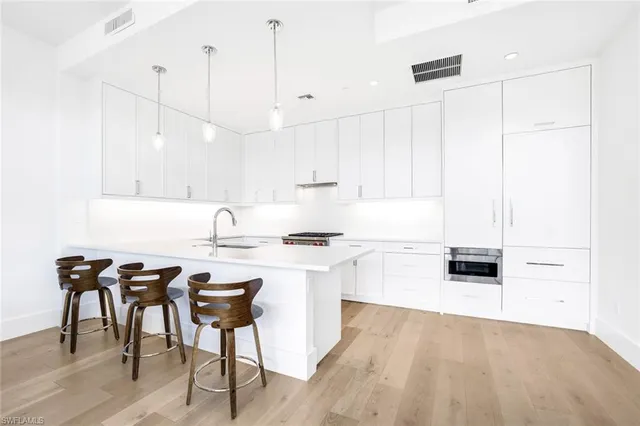 a kitchen with a table chairs stove and white cabinets